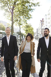 Smiling colleagues walking in street