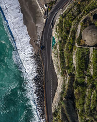 Aerial view of sea waves by road