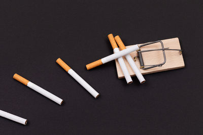 High angle view of cigarette on table against black background
