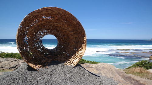 Stone structure on beach against sky