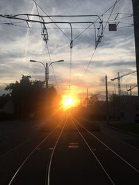Railroad tracks against sky during sunset