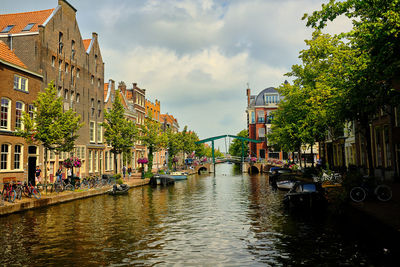 Canal amidst buildings in city against sky