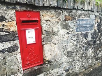 Close-up of red mailbox on wall