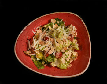 Close-up of food in plate against black background