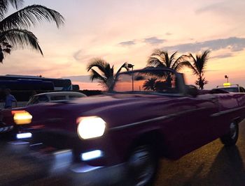 Cars on car against sky during sunset