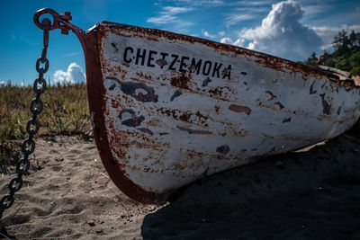 Close-up of rusty sign on beach