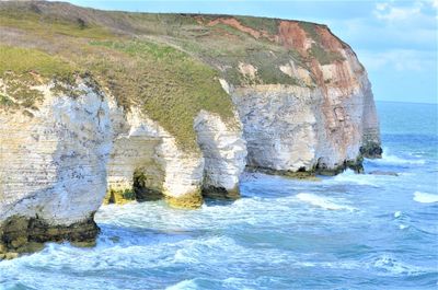 Rock formations by sea against sky