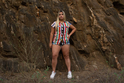 Full length portrait of a woman standing on rock