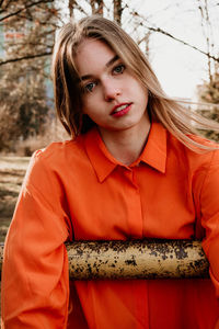 Portrait of beautiful woman standing against trees