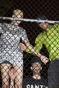 Shadow of people on chainlink fence