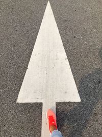 Low section of woman standing on road marking