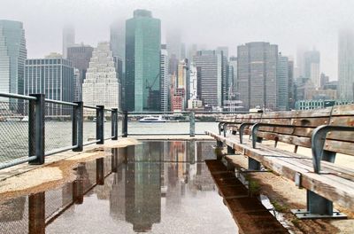 Bridge over river in city against sky