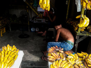 Full length of shirtless man at market stall