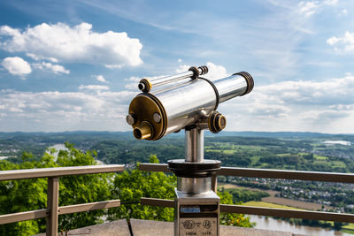 Paid single lens telescope, set on a high vantage point with a view of the city.