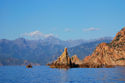 Panoramic view of sea and mountains against blue sky