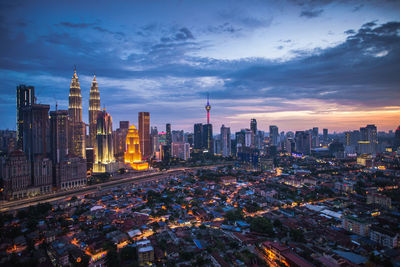 Illuminated modern buildings in city at dusk