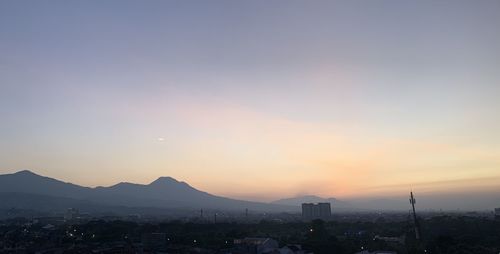 Silhouette buildings against sky during sunset