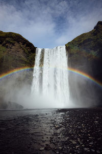 Scenic view of waterfall against sky