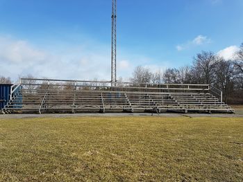 View of field against cloudy sky