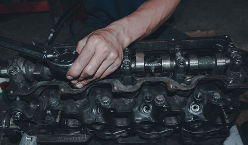 The mechanic is checking the engine.