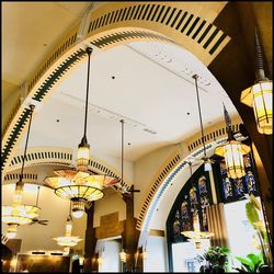 Low angle view of illuminated pendant lights hanging in building