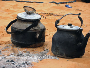High angle view of burnt kettles on sand in desert