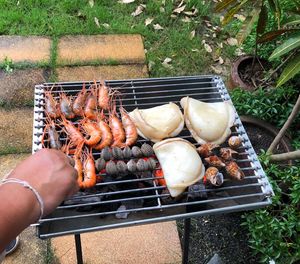 High angle view of person preparing food on barbecue grill