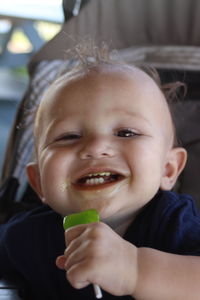 Close-up portrait of smiling boy eating