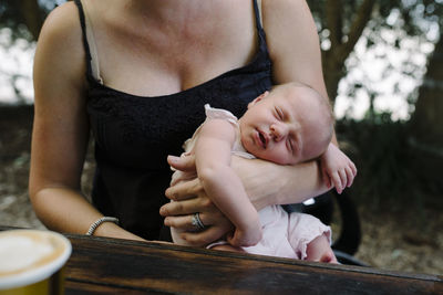 Midsection of mother holding baby girl