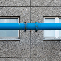 The blue water pipe in front of the windows of the prefabricated house