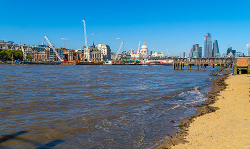 View of sea and buildings against blue sky