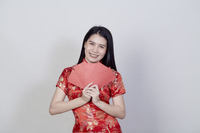 Portrait of a smiling young woman against white background