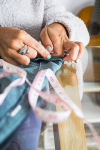 Midsection of woman sewing cloth at work shop