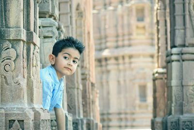 Portrait of boy amongst columns