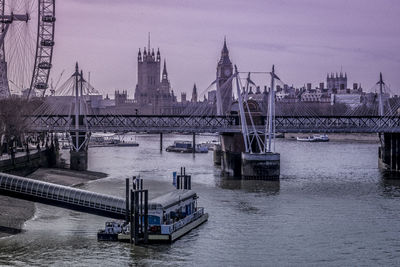 Bridge over river against sky in city