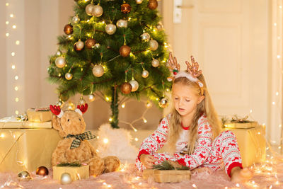 Young woman decorating christmas tree