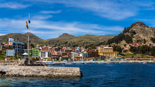 Houses by sea against sky