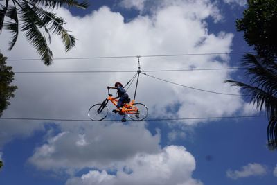 Low angle view of man riding bicycle against sky