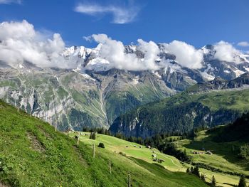 Panoramic view of green landscape and mountains against sky