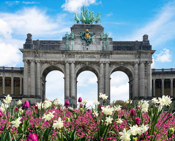 View of flowering plants in front of historical cinquantenaire