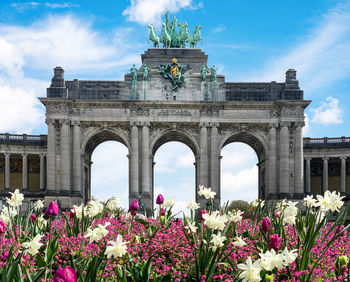 View of flowering plants in front of historical building