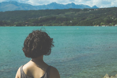 Rear view of young woman looking at sea