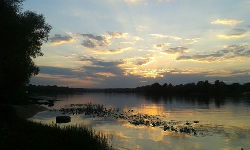 Scenic shot of calm lake at sunset