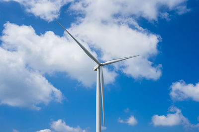 Low angle view of windmill against blue sky