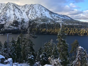 Scenic view of lake by snowcapped mountains against sky