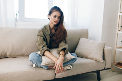 Portrait of woman sitting on sofa at home