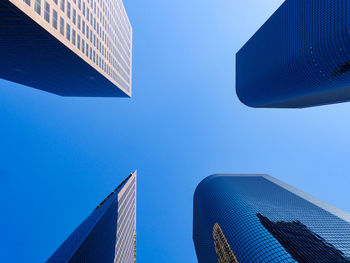 Low angle view of modern buildings against blue sky