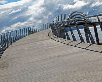 Footbridge over sea against sky