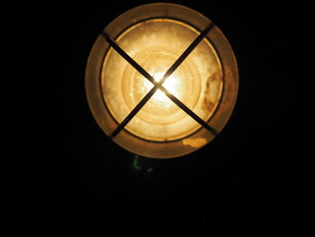 Low angle view of illuminated lamp in darkroom