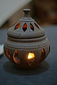 Close-up of illuminated lamp on table